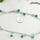 Green Glass Crystal Dangle and Chain Anklet beside a dime.