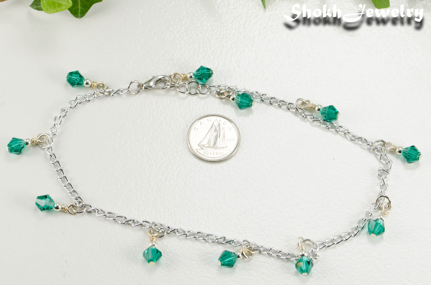 Green Glass Crystal Dangle and Chain Anklet beside a dime.