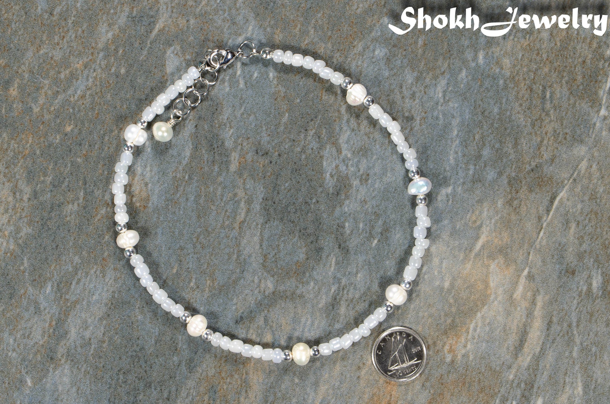 Freshwater Pearl and White Seed Bead Choker Necklace with Silver Plated Spacers beside a dime.