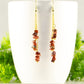 Long Gold Plated Chain and Red Jasper Chip Earrings displayed on a coffee mug.