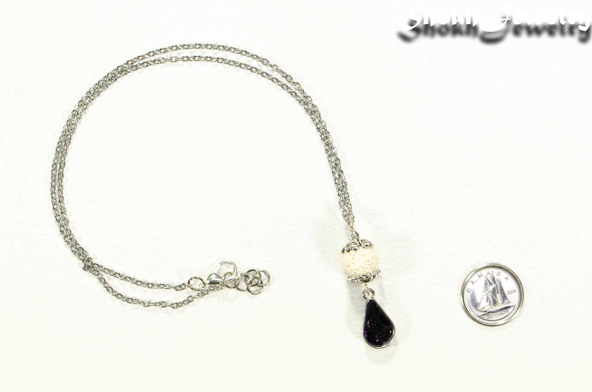 Lava Rock and Teardrop February Birthstone Choker Necklace beside a dime.