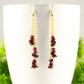 Close up of Long Gold Plated Chain and Garnet Crystal Chip Earrings.