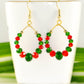 Green and Red Glass Crystal Hoop Earrings displayed on a tea cup.