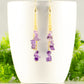 Long Gold Plated Chain and Amethyst Crystal Chip Earrings displayed on a coffee mug.