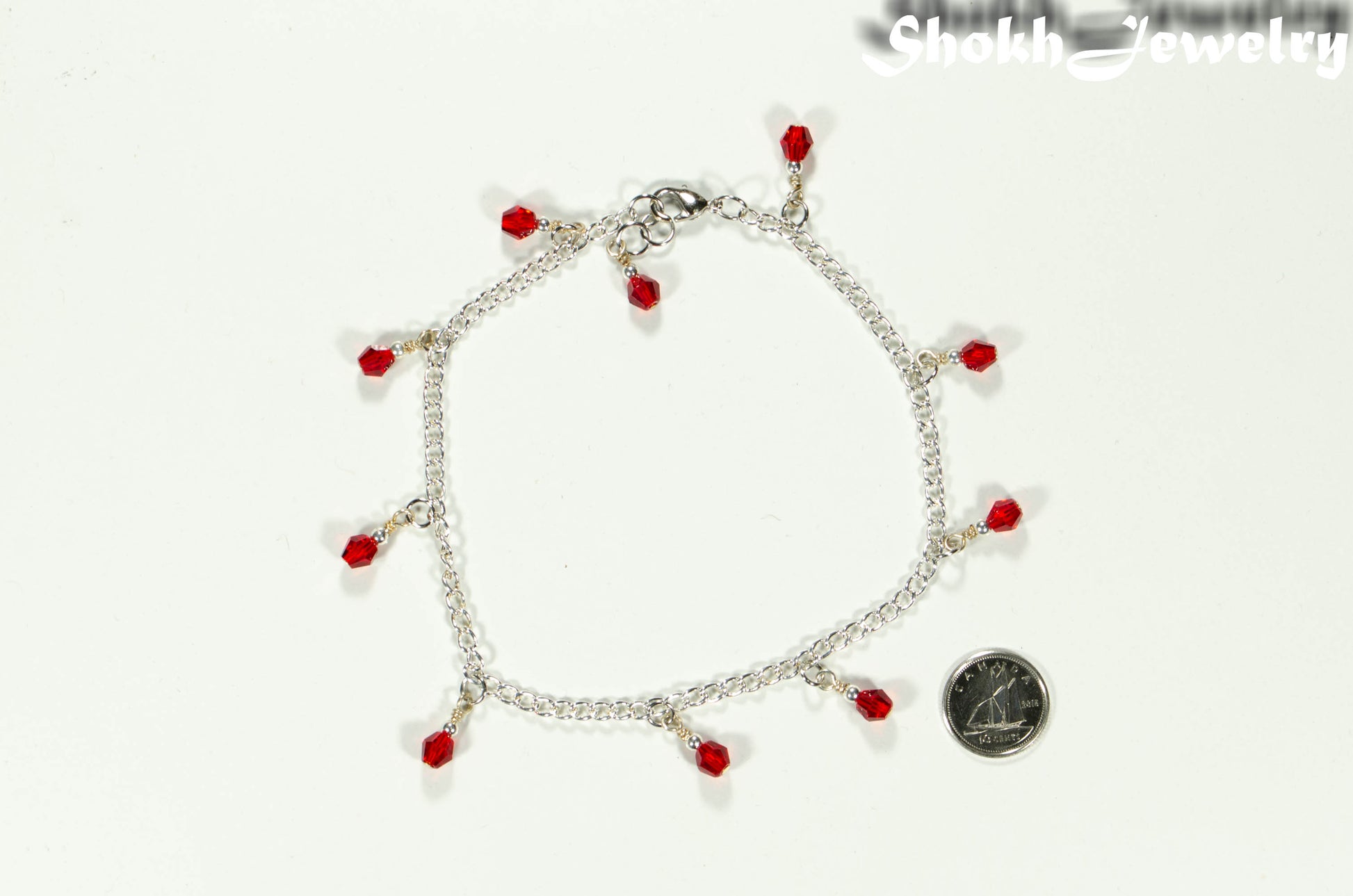 Red Glass Crystal Dangle and Chain Anklet beside a dime.