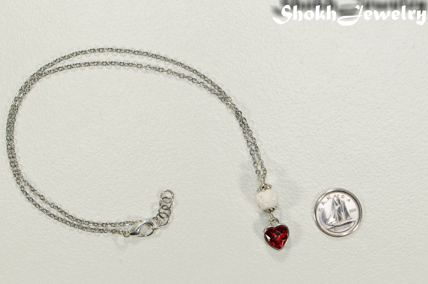 Lava Rock and Heart Shaped July Birthstone Choker Necklace beside a dime.