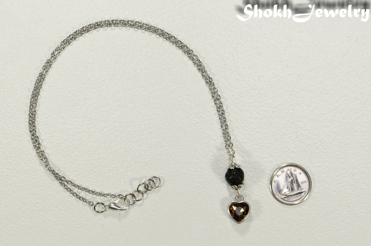 Lava Rock and Heart Shaped November Birthstone Choker Necklace beside a dime.