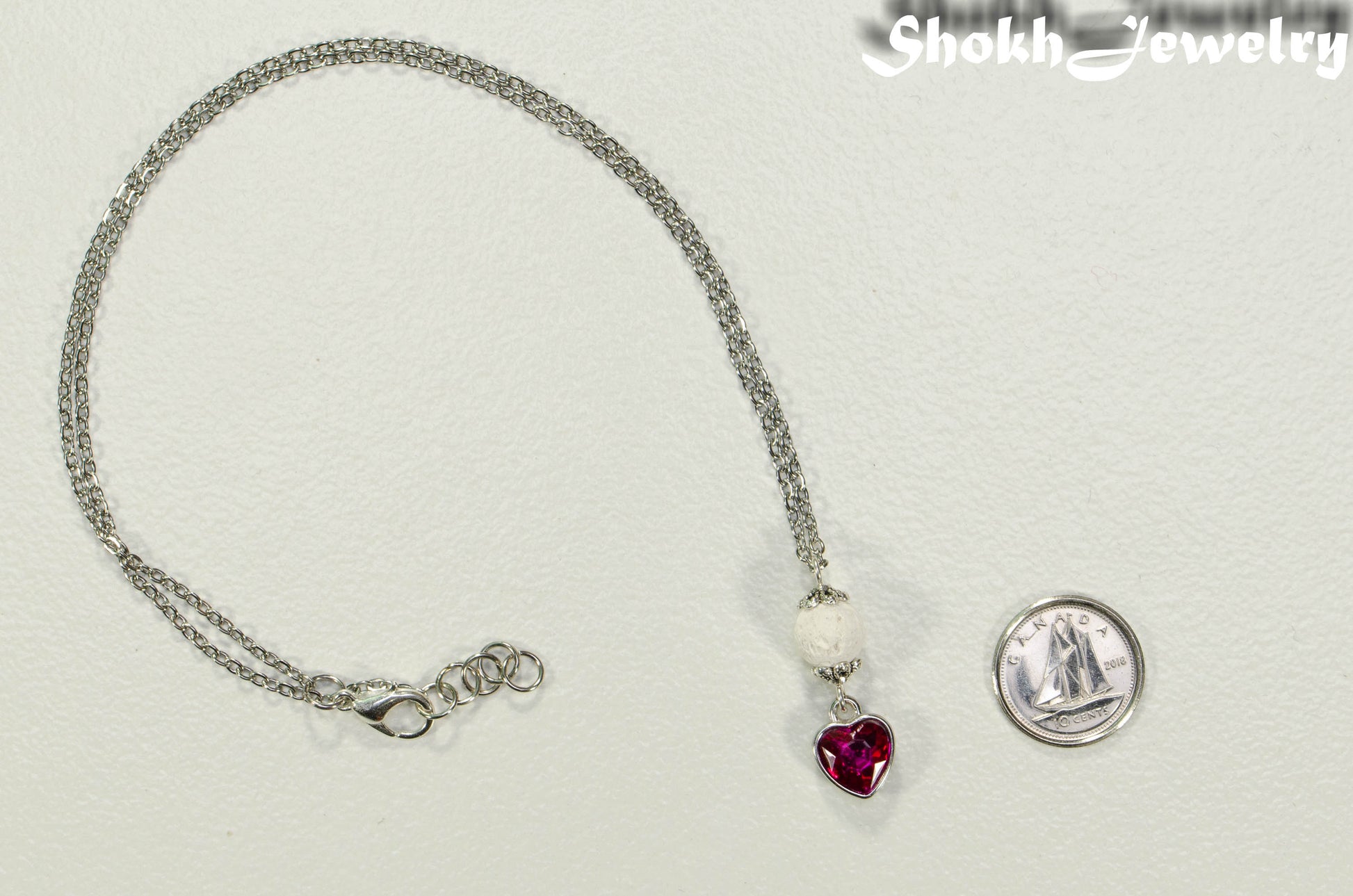 Lava Rock and Heart Shaped October Birthstone Choker Necklace beside a dime.