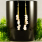 Long Gold Plated Chain and Rose Quartz Crystal Chip Earrings displayed on a coffee mug.