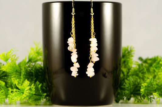 Long Gold Plated Chain and Rose Quartz Crystal Chip Earrings displayed on a coffee mug.