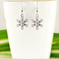 Christmas Snowflakes Charm Earrings displayed on  a tea cup.