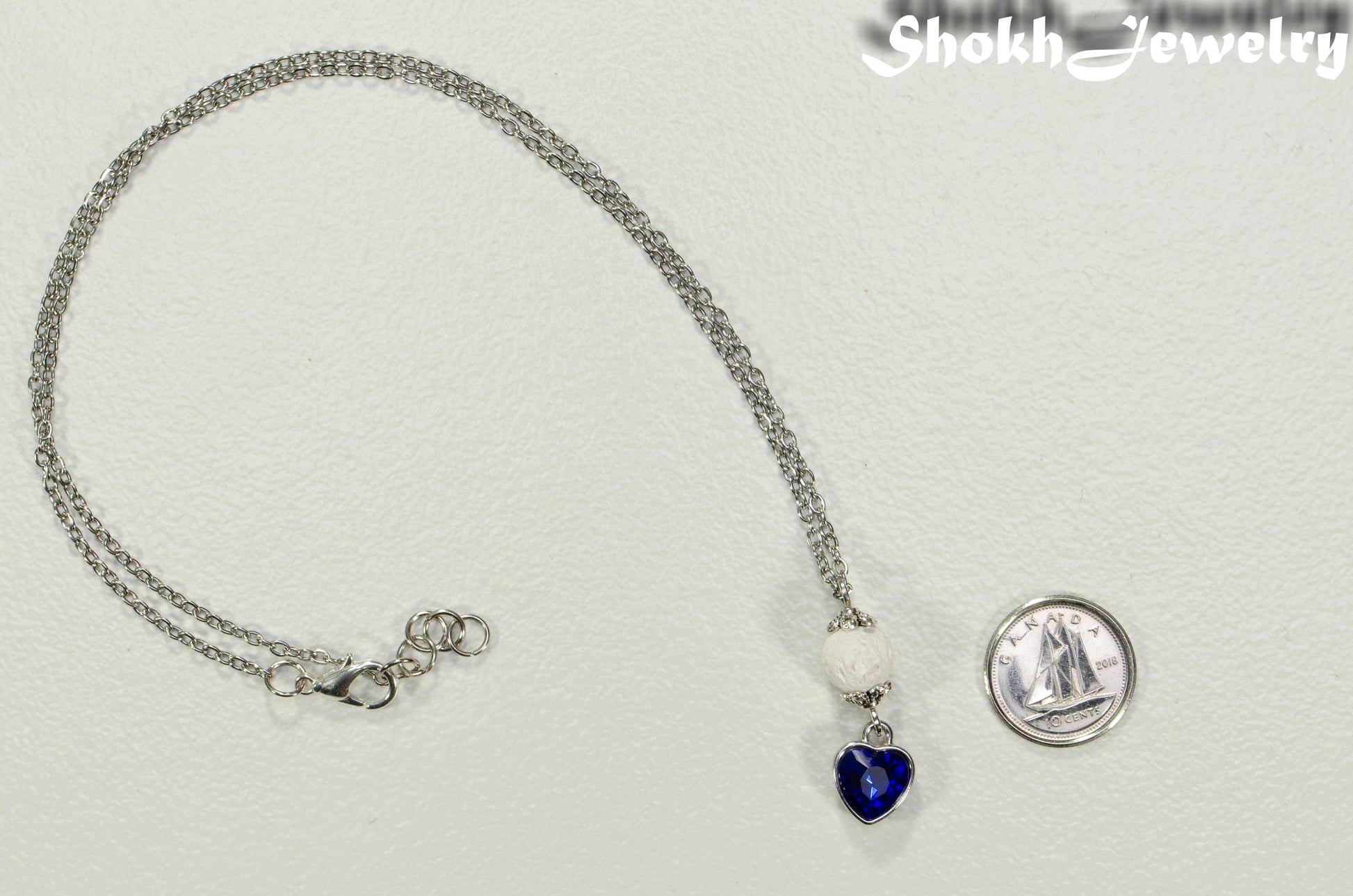 Lava Rock and Heart Shaped September Birthstone Choker Necklace beside a dime.