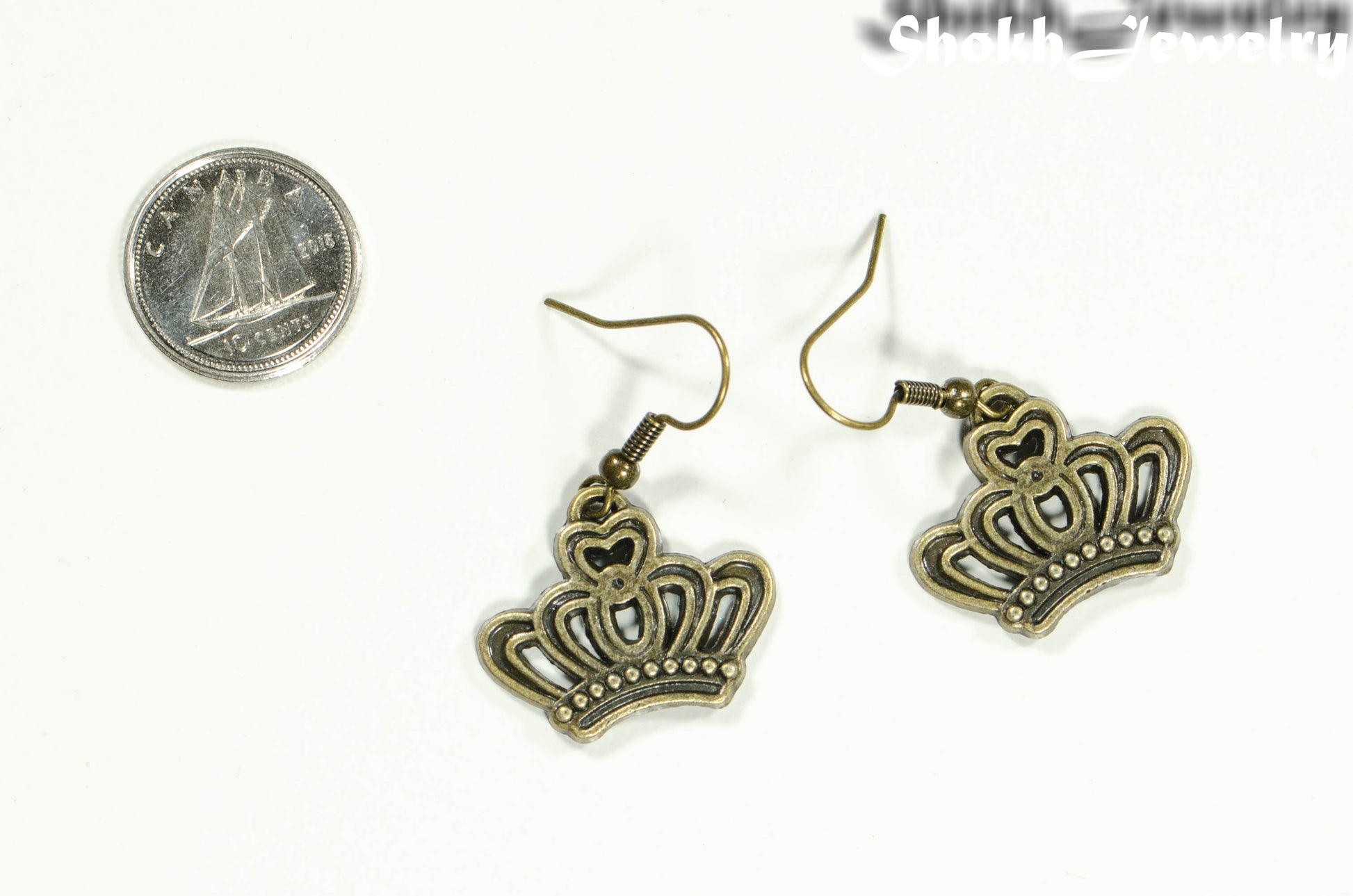 Antique Bronze Crown Charm Earrings beside a dime.
