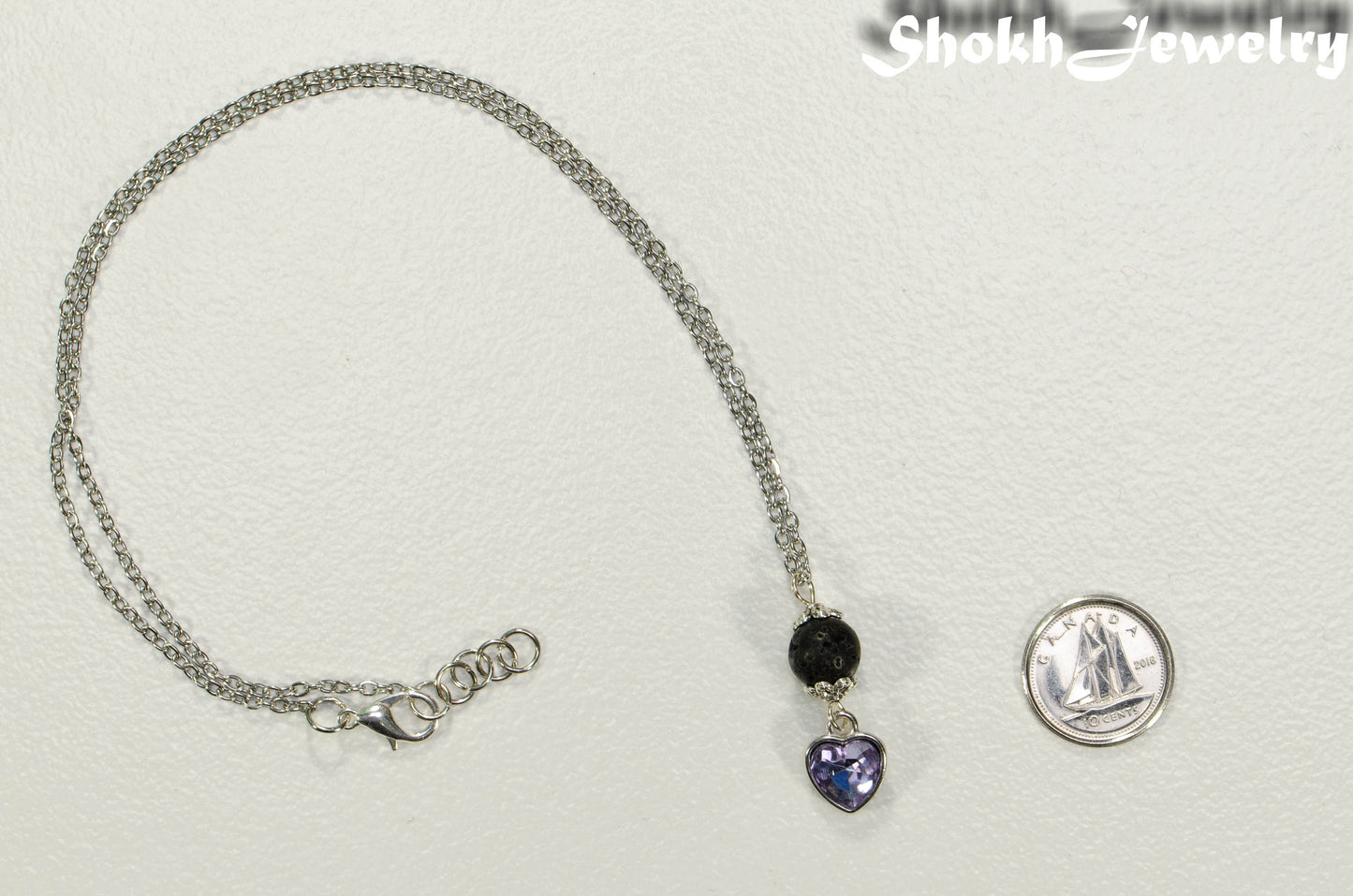 Lava Rock and Heart Shaped June Birthstone Choker Necklace beside a dime.