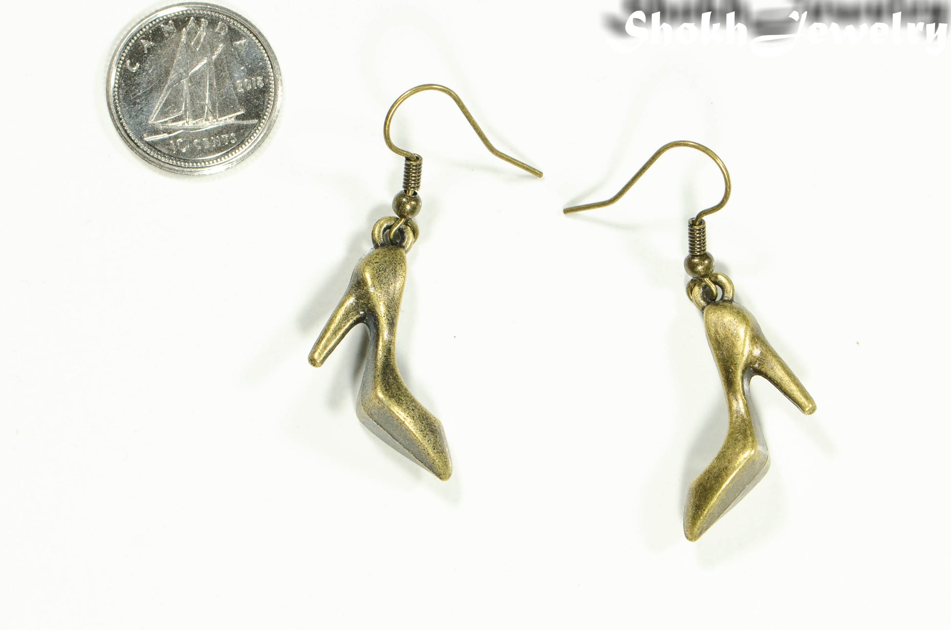 Antique Bronze High Heel Shoe Charm Earrings beside a dime.