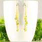 Long Gold Plated Chain and Peridot Chip Earrings displayed on a coffee mug.