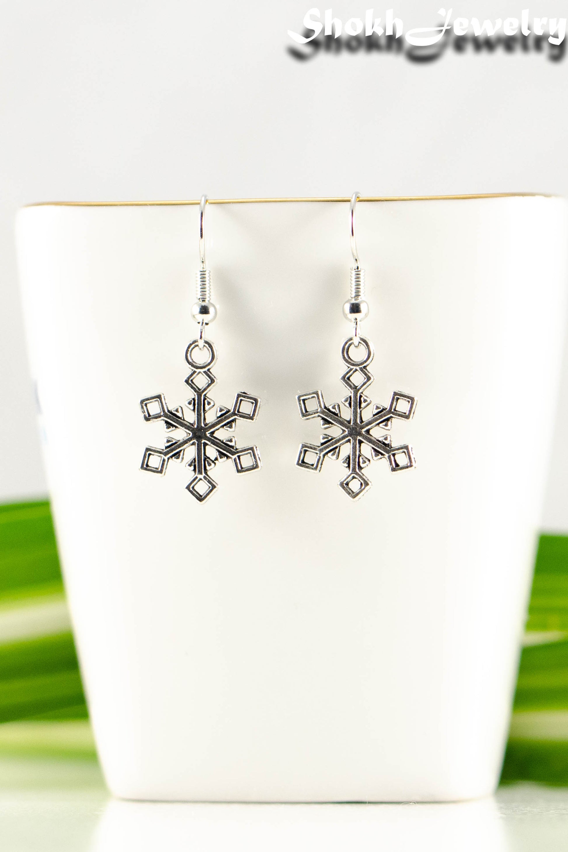 Close up of Christmas Snowflakes Charm Earrings.