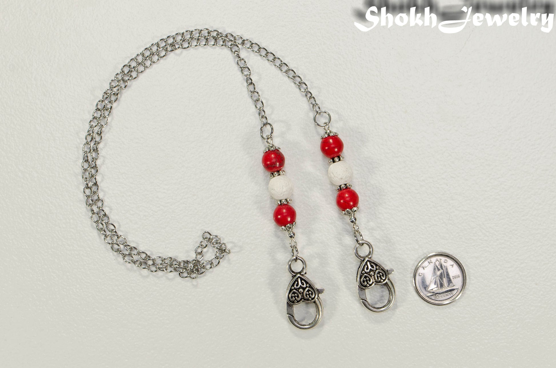 8mm Red Howlite and White Lava Stone Eyeglass Chain. beside a dime.