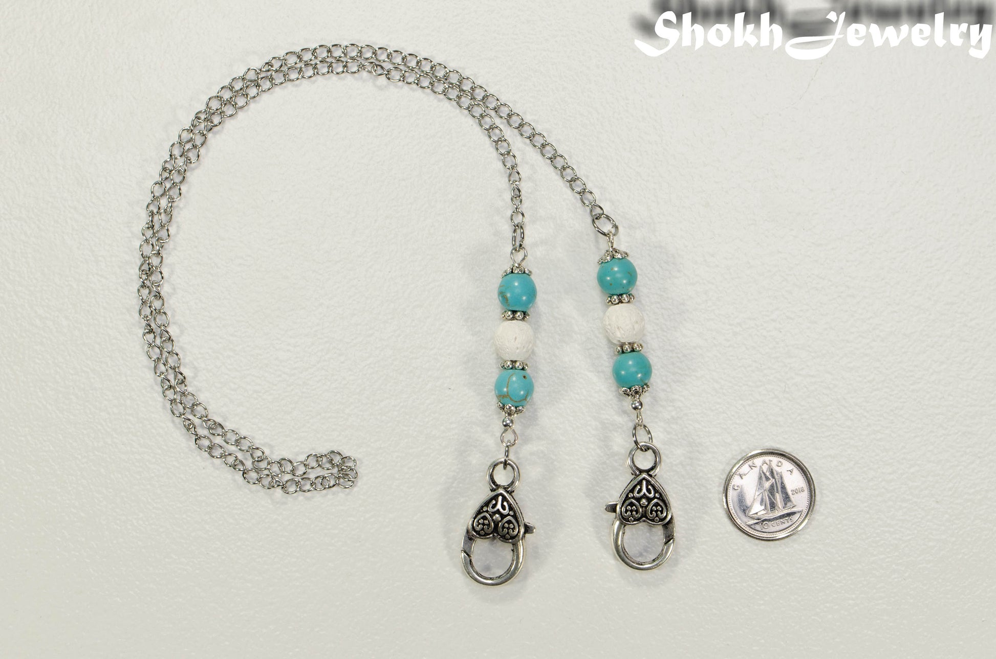 8mm Turquoise Howlite and White Lava Stone Eyeglass Chain beside a dime.