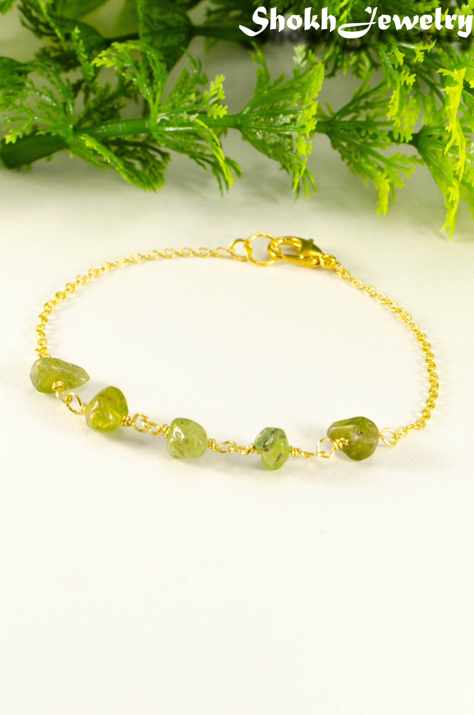 Close up of Peridot Crystal Chip and Gold Plated Chain Bracelet.