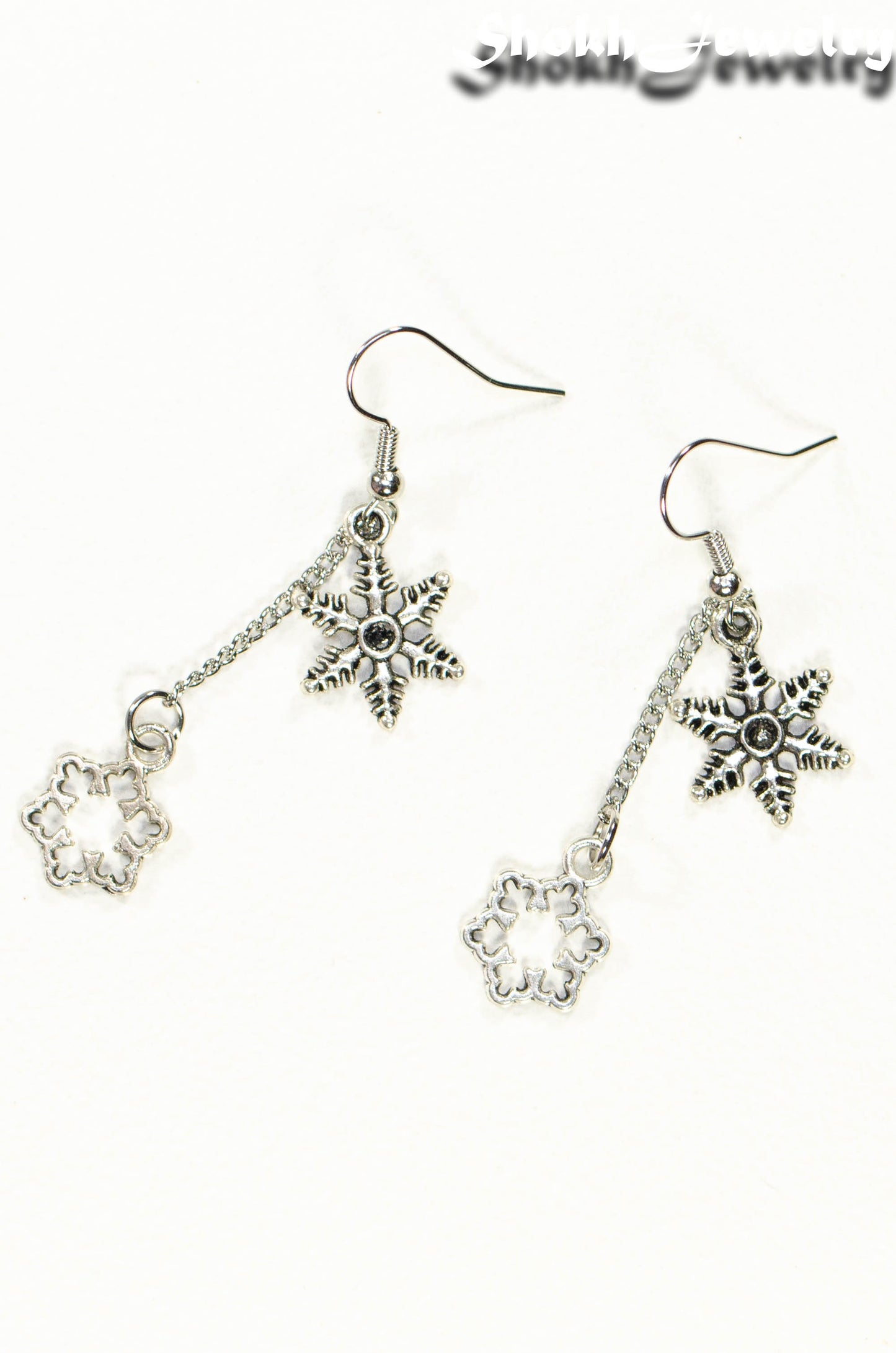 Top view of Long Chain and Snowflakes Charm Earrings.