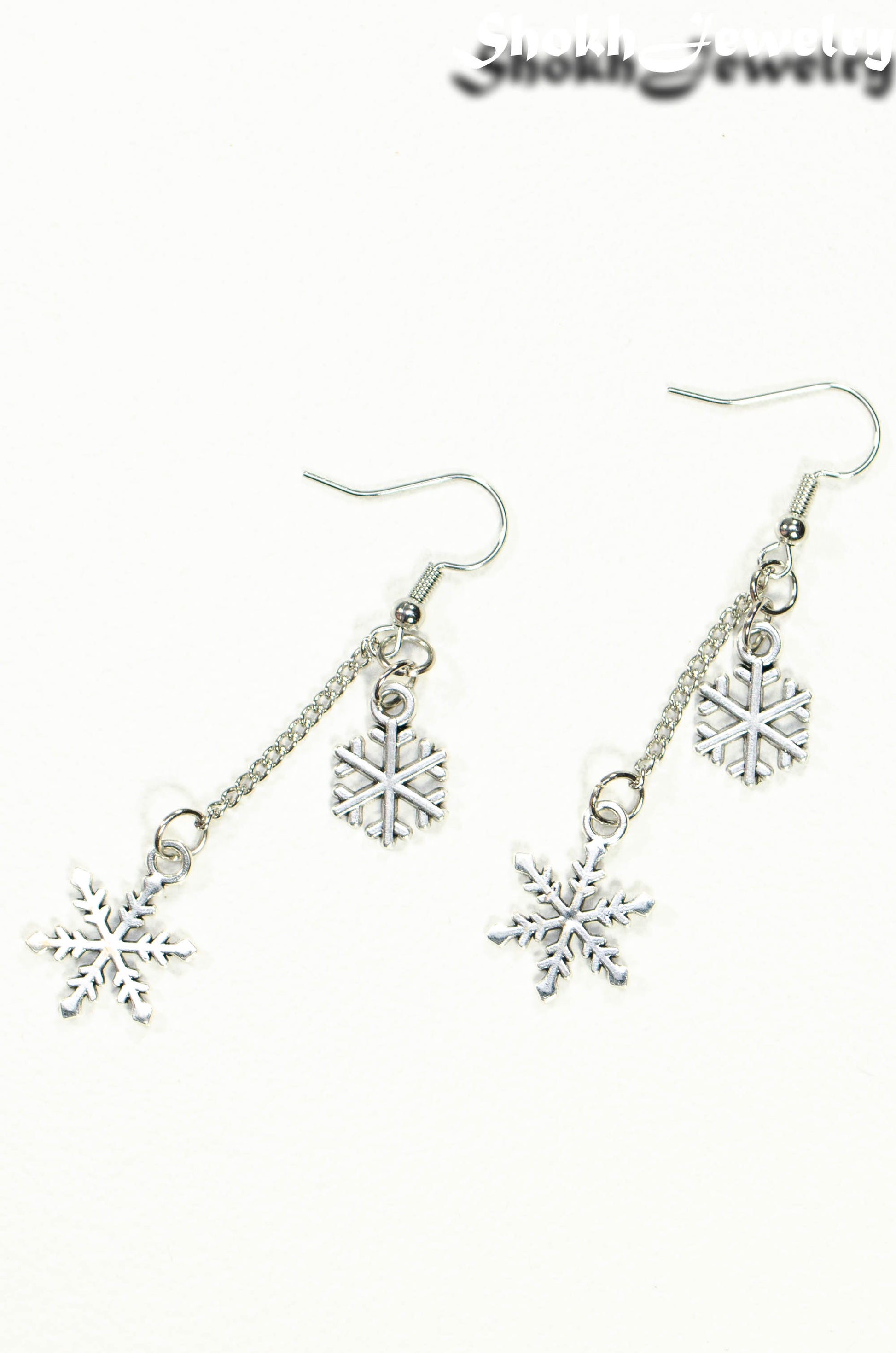 Top view of Long Chain and Snowflakes Charm Earrings.