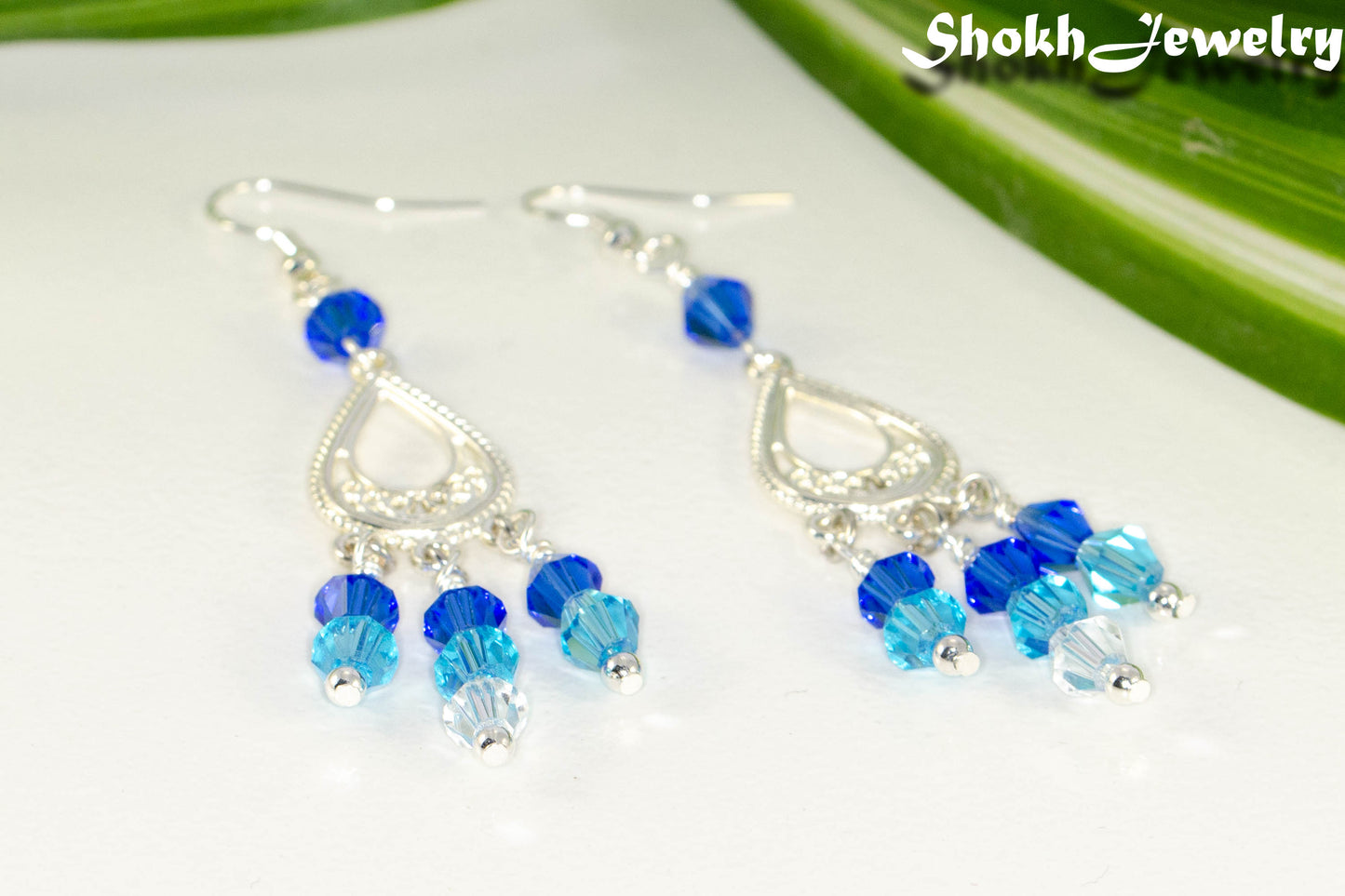 Close up of Ombre Blue Glass Crystal Chandelier Earrings.