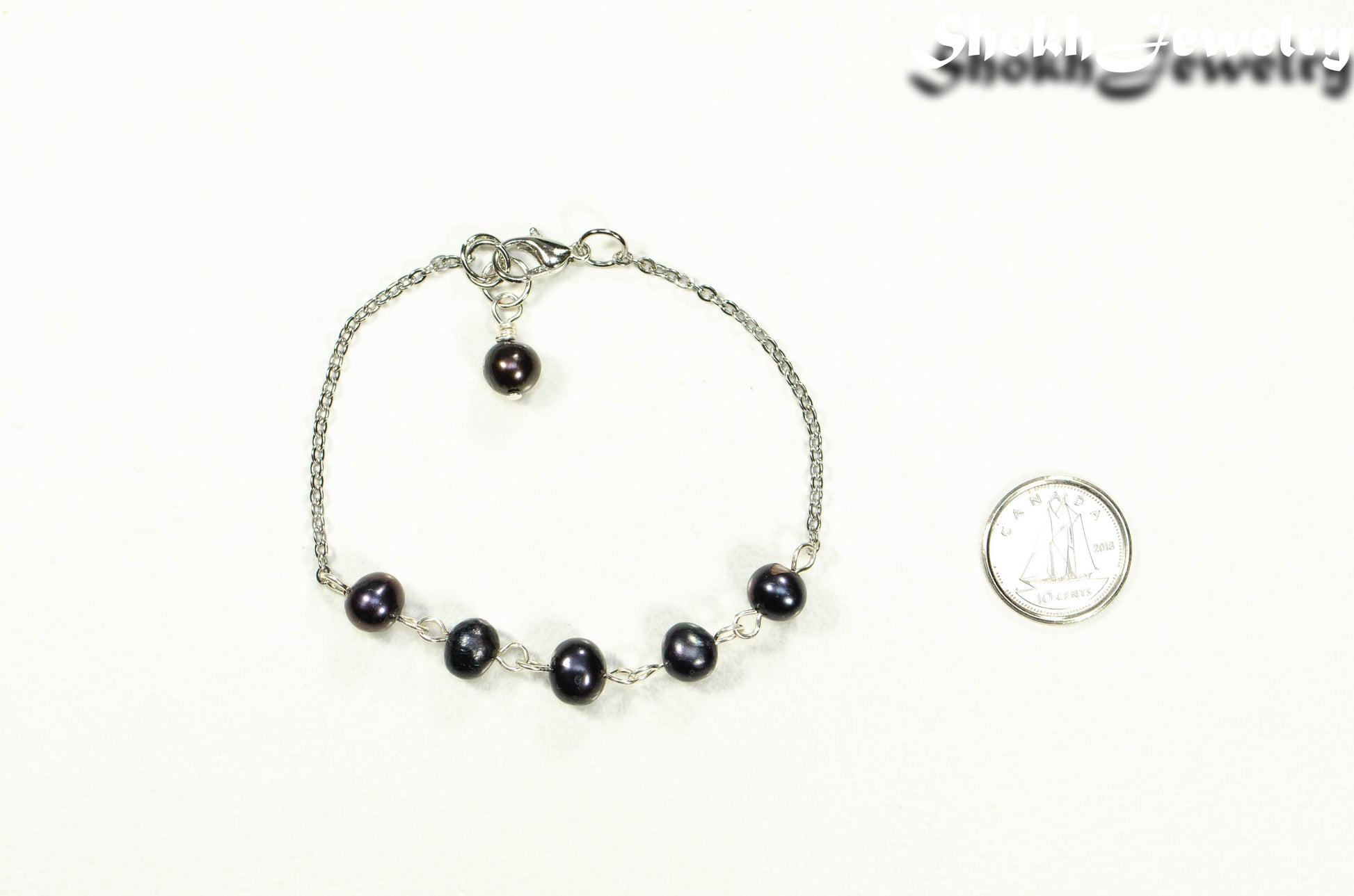 Black Pearl and Stainless Steel Chain Anklet beside a dime.