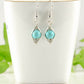 Turquoise Howlite Wire Wrapped Earrings displayed on a tea cup.