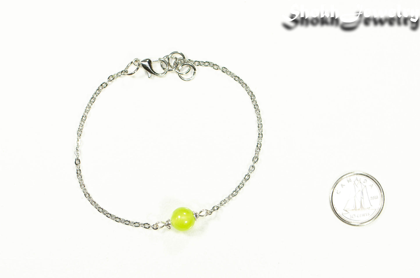 8mm Peridot and Chain Anklet beside a dime.