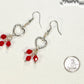 Silver Plated Heart and Red Glass Crystal Cluster Earrings beside a dime.