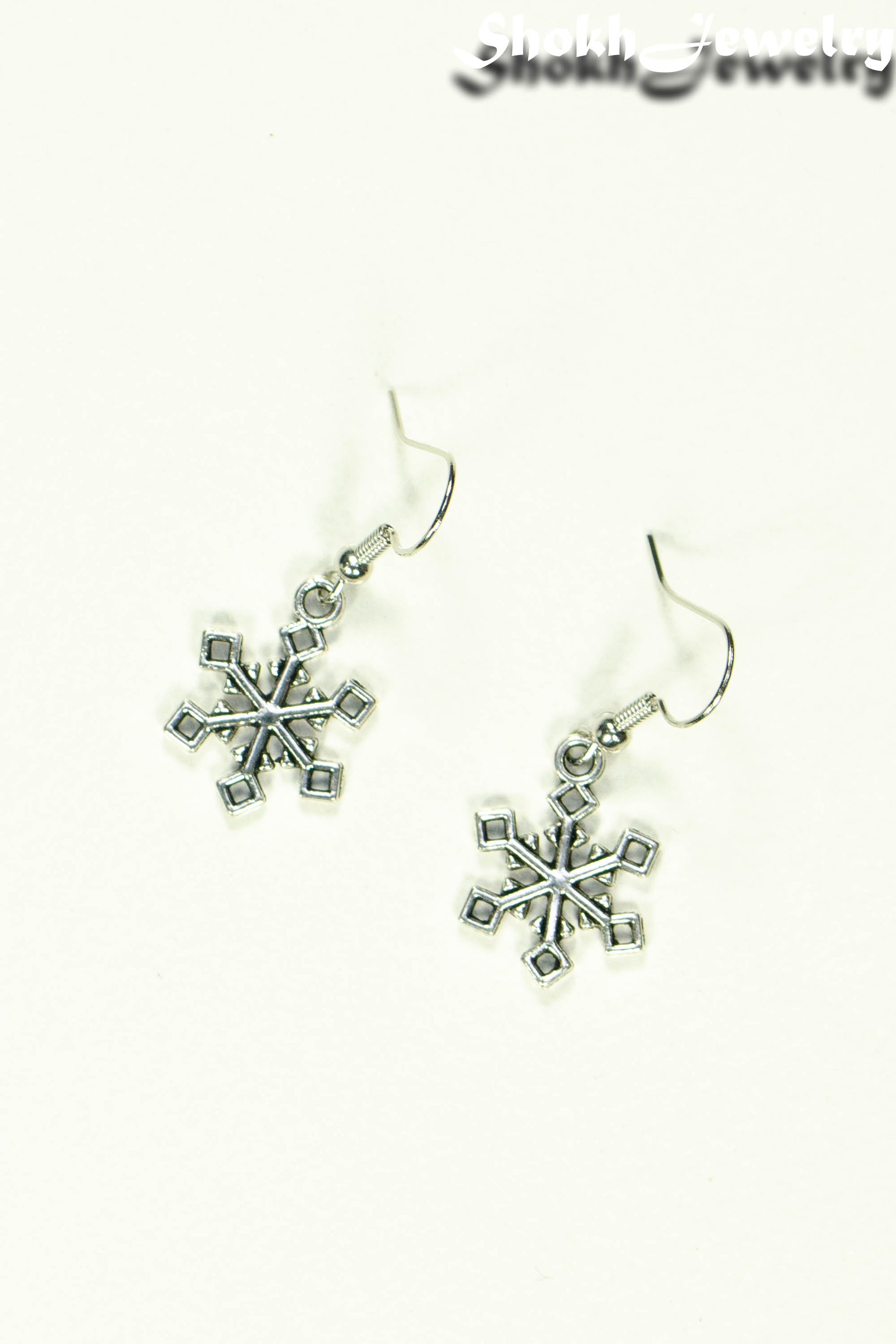 Top view of Christmas Snowflakes Charm Earrings.