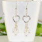 Silver Plated Heart and Clear Glass Crystal Cluster Earrings displayed on a tea cup.