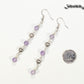 Long Amethyst and Heart Earrings beside a dime.