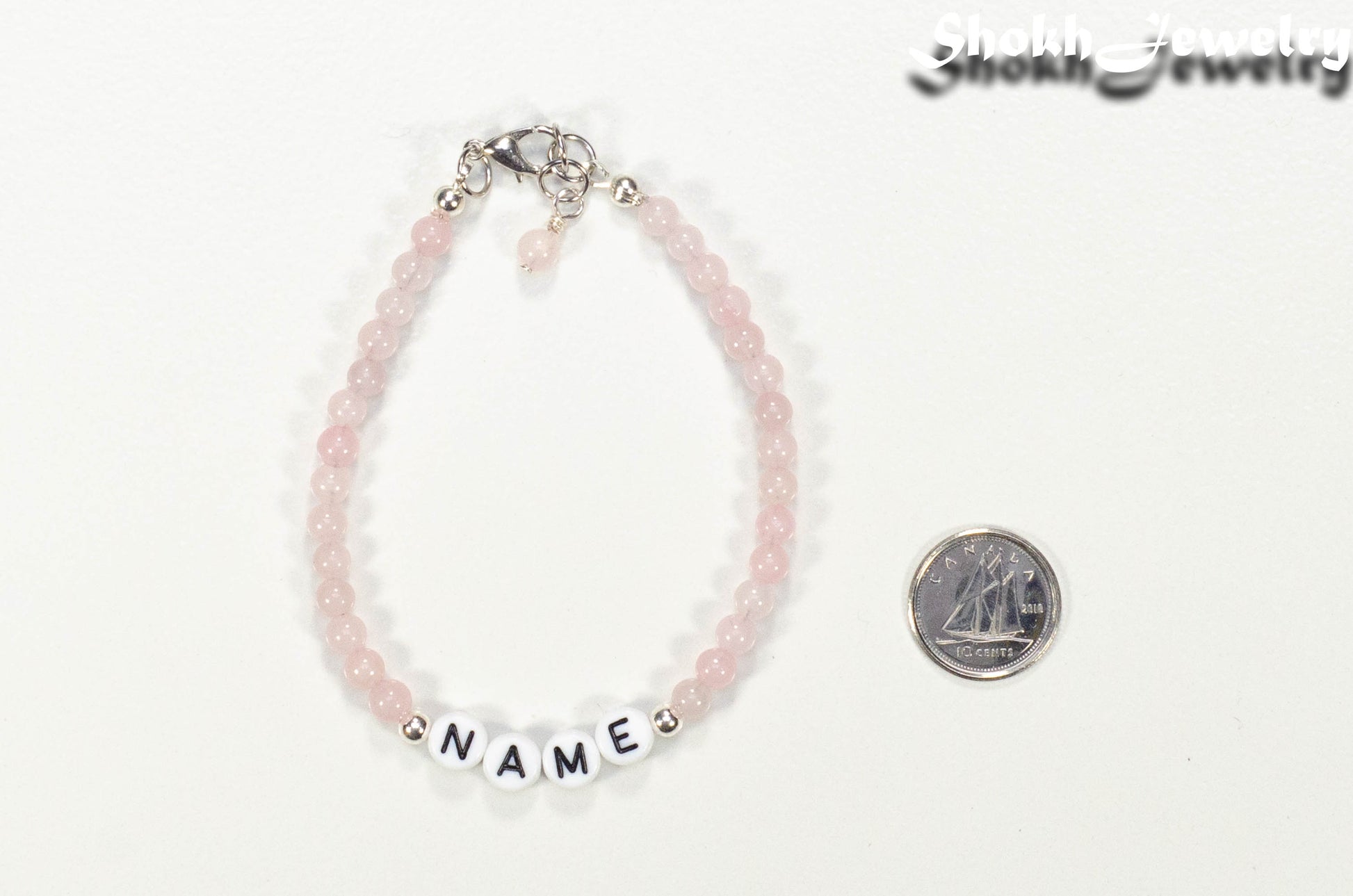 Personalized Rose Quartz Name Bracelet with Clasp beside a dime.