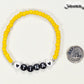 Yellow Seed Beads Name Bracelet beside a dime.