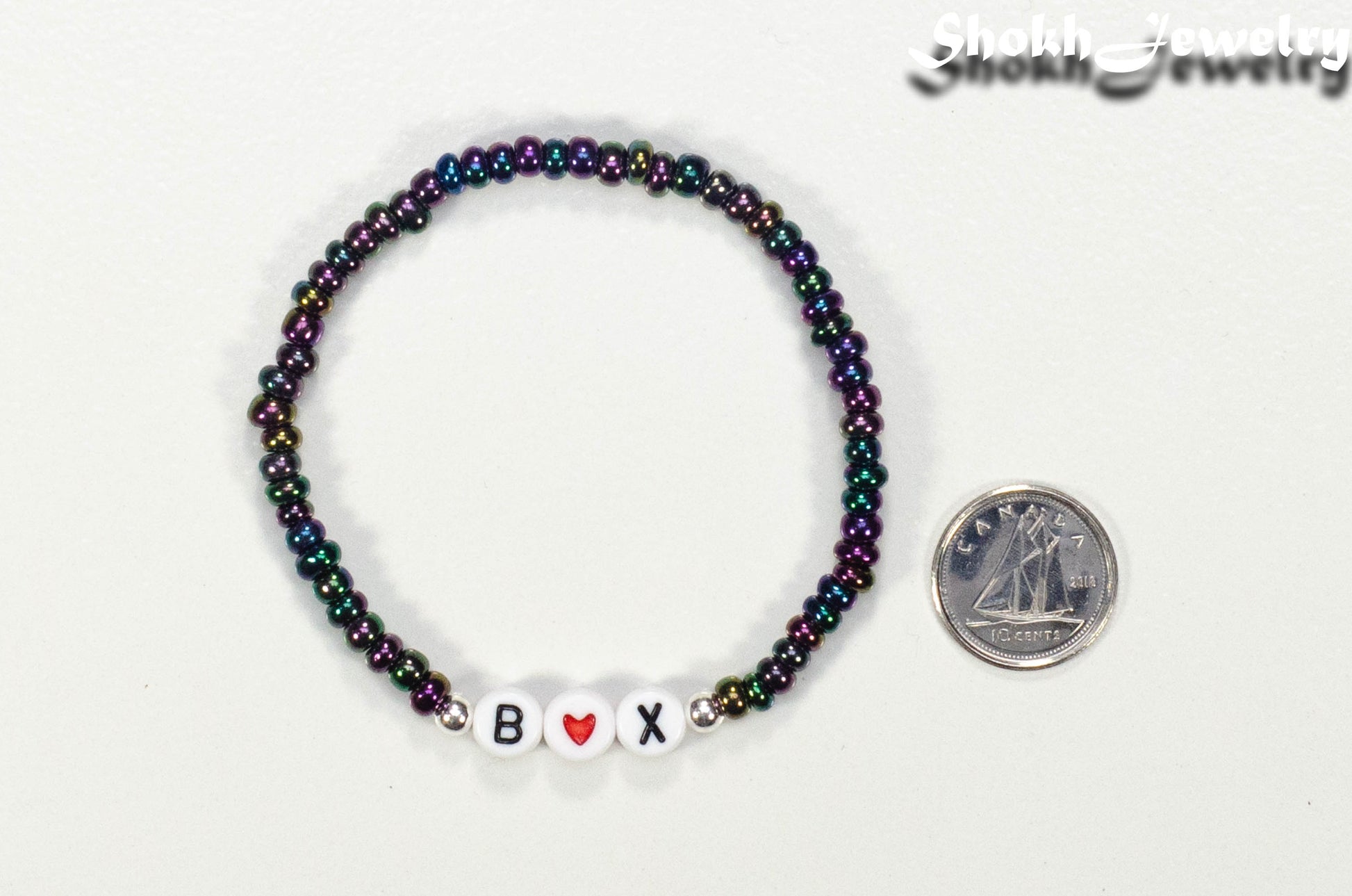 Metallic Black Seed Beads Bracelet with Initials beside a dime.