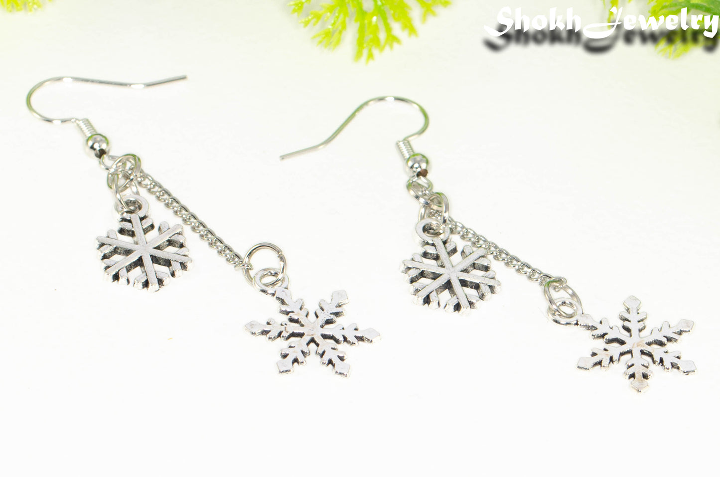 Close up of Long Chain and Snowflakes Charm Earrings.