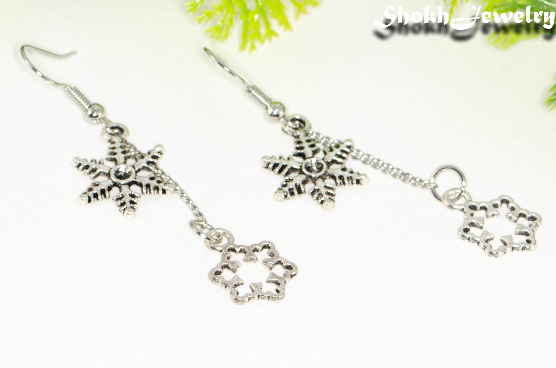 Close up of Long Chain and Snowflakes Charm Earrings.