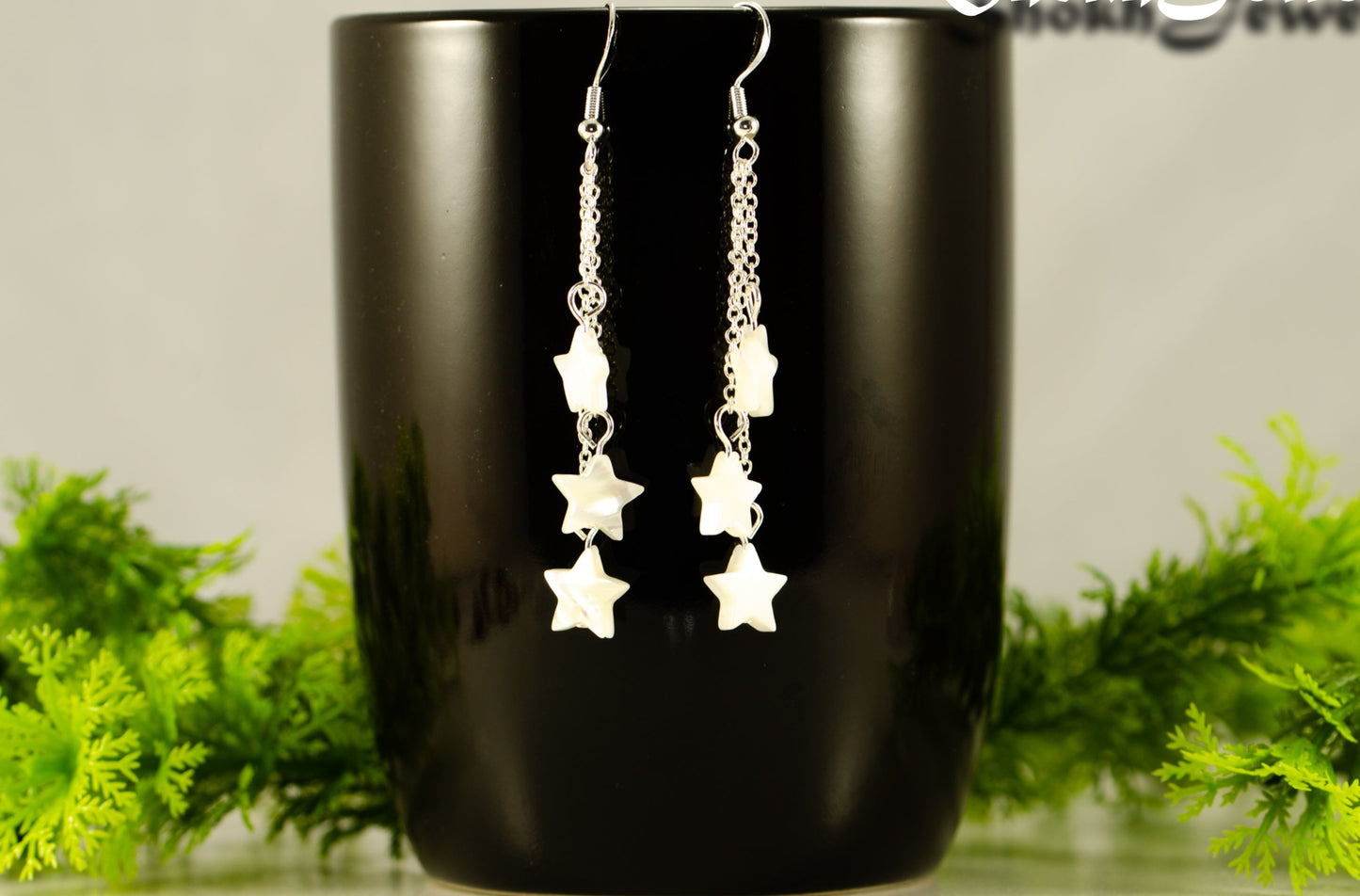 Long Silver Plated Chain and Seashell Star Earrings displayed on a coffee mug.