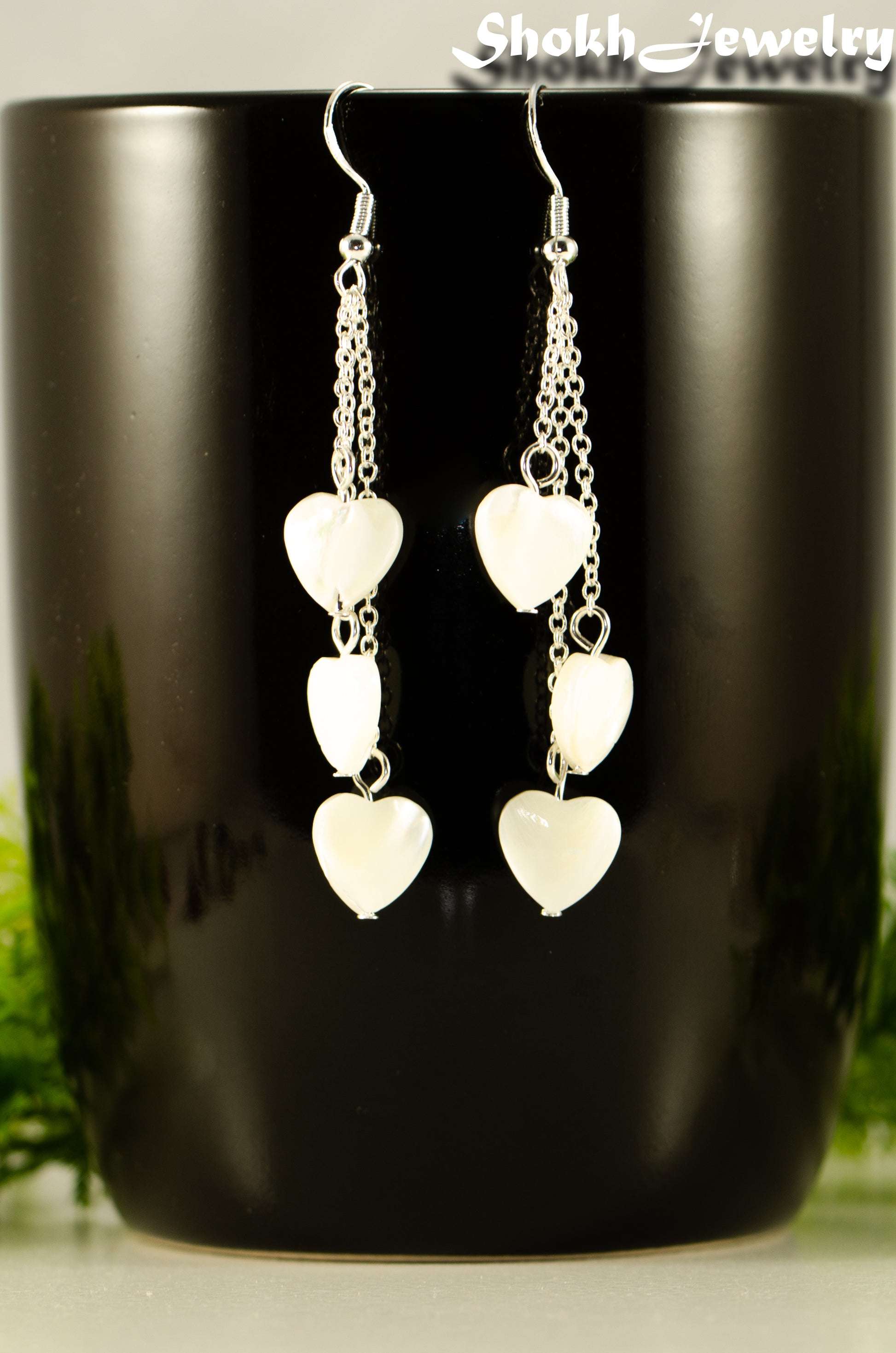 Close up of Long Silver Plated Chain and Seashell Heart Earrings.