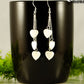 Long Silver Plated Chain and Seashell Heart Earrings displayed on a coffee mug.