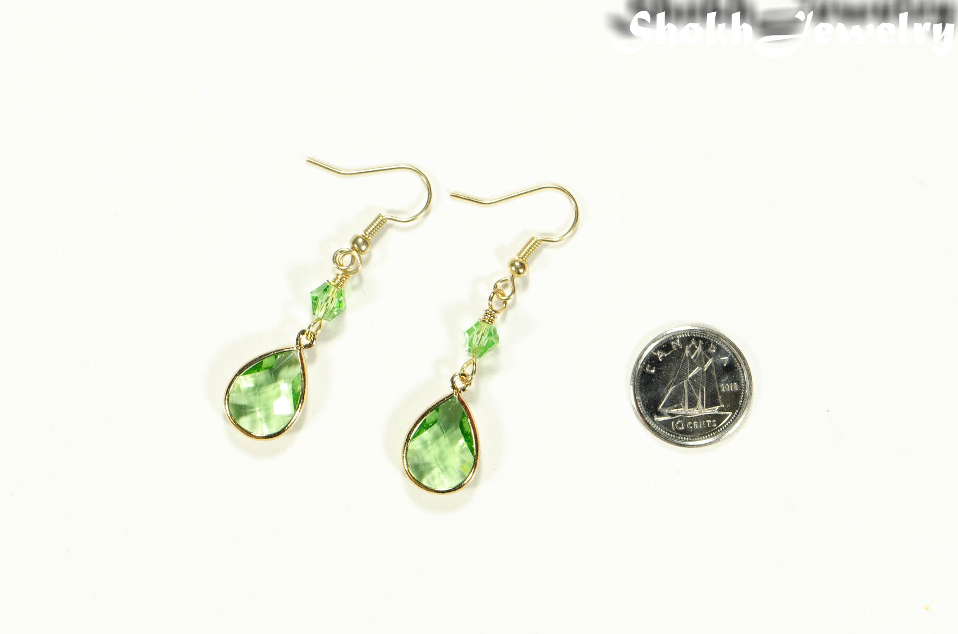 Green Glass Teardrop Dangle Earrings beside a dime.