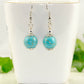 12mm Turquoise Howlite Dangle Earrings displayed on a tea cup.