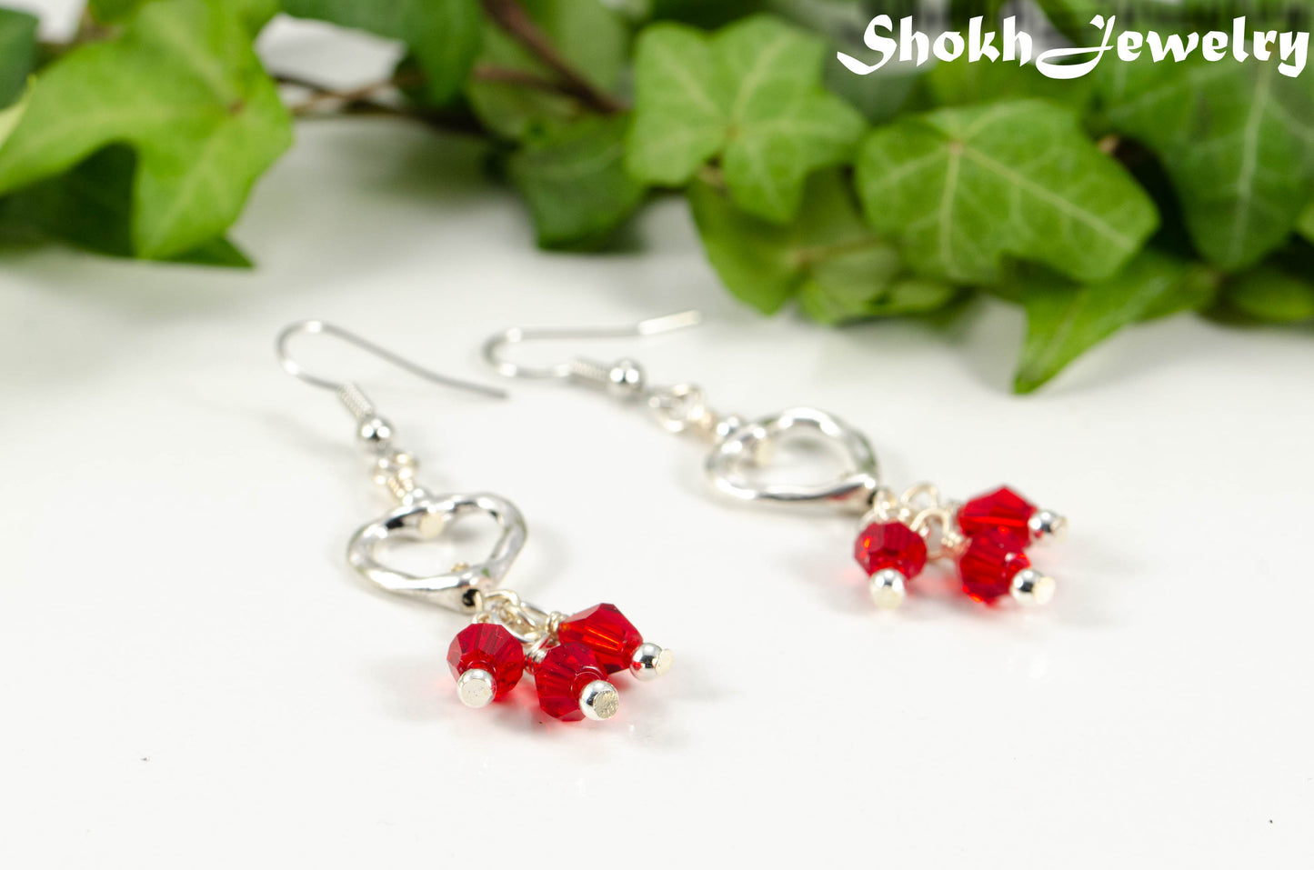 Close up of Silver Plated Heart and Red Glass Crystal Cluster Earrings.