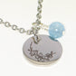 Close up of March Birth Flower Necklace with Aquamarine Birthstone Pendant.