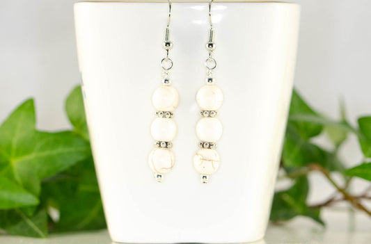 Natural White Howlite Beaded Bar Earrings displayed on a tea cup.
