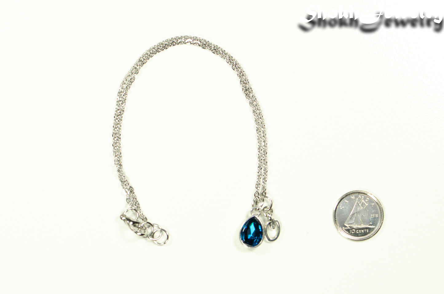 Small Personalized December Birthstone Choker Necklace beside a dime.