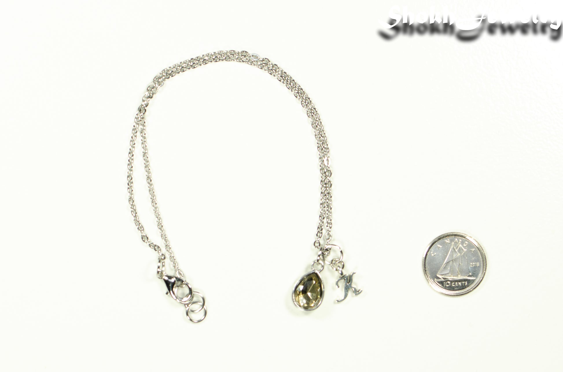 Small Personalized April Birthstone Choker Necklace beside a dime.