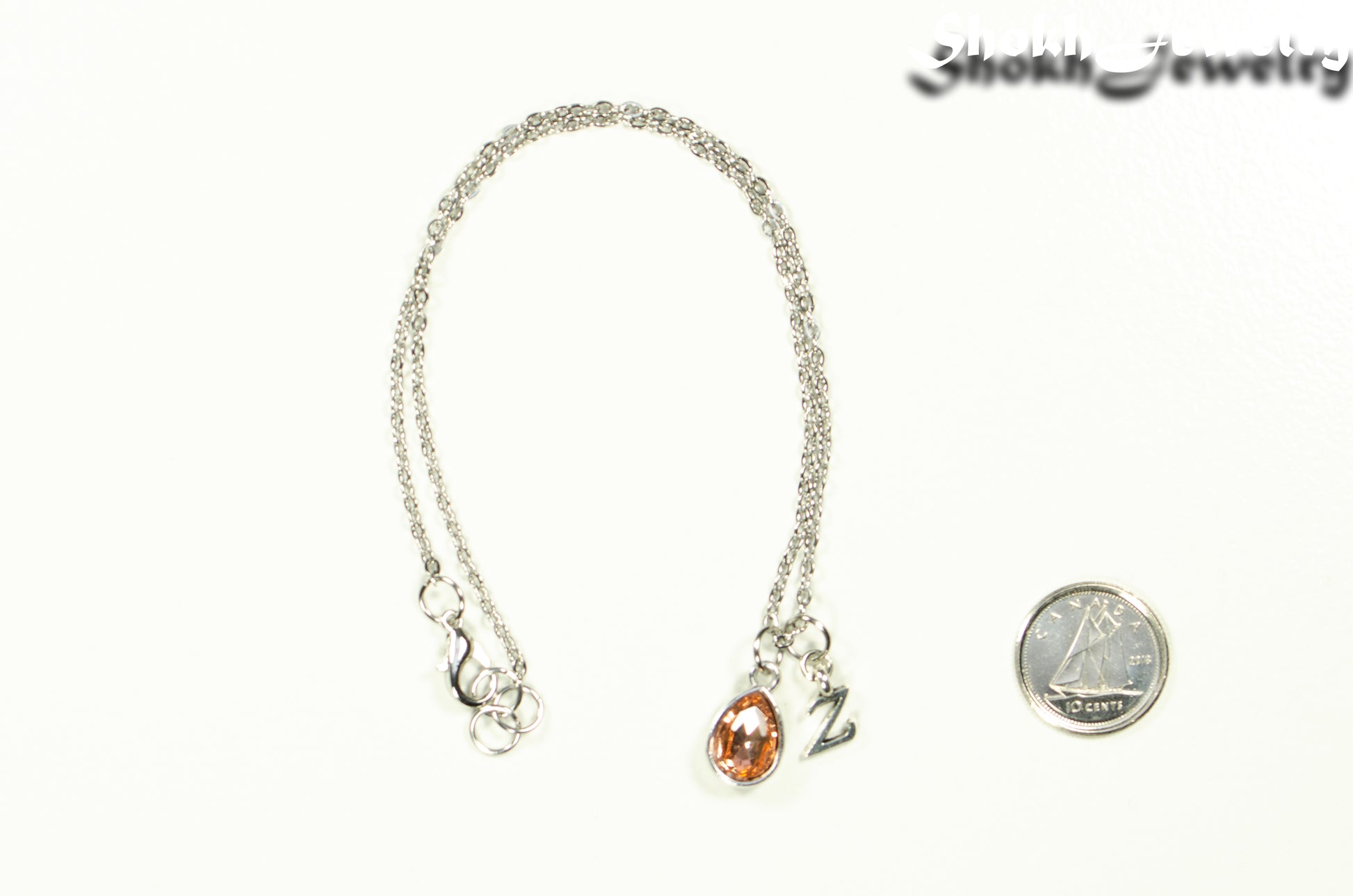 Small Personalized July Birthstone Choker Necklace beside a dime.